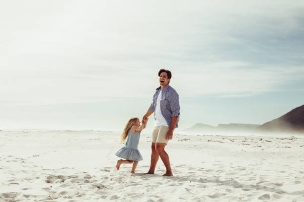 istock Father and daughter having fun playing on the beach. 1252858532