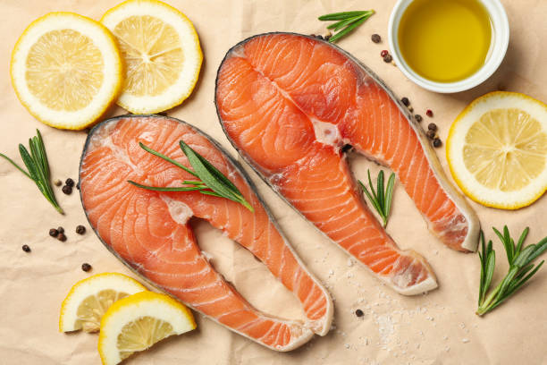 istock Salmon meat and spices on baking paper background, top view 1252859476