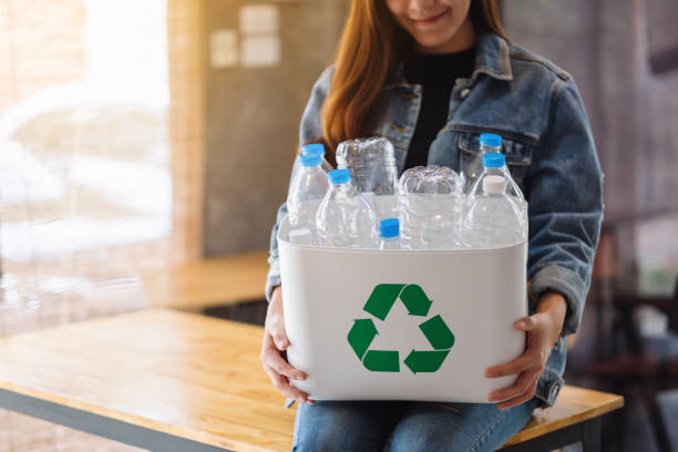 istock A woman collecting and holding a recyclable garbage plastic bottles in a trash bin 1252859536