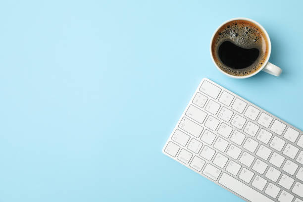 istock White keyboard and coffee on blue background, top view 1252861950