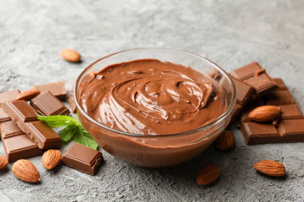 istock Bowl with chocolate and chocolate pieces on gray background 1252863174