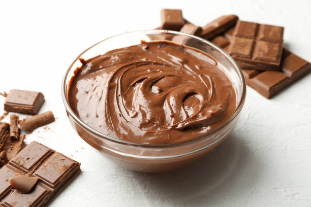 istock Bowl with chocolate and chocolate pieces on white background 1252864424