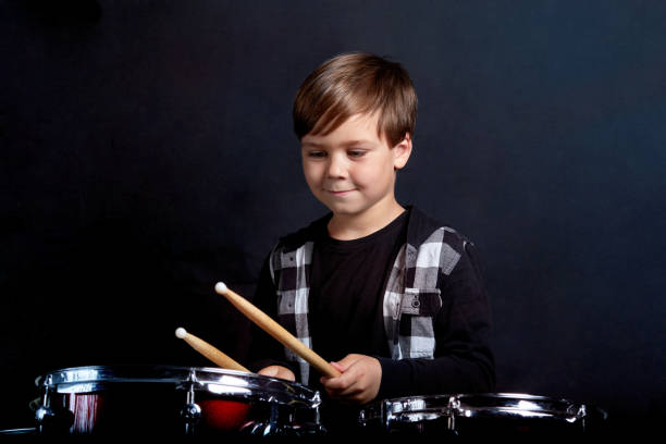 istock A brunette child boy plays the drums. Studying in the studio. 1252866589