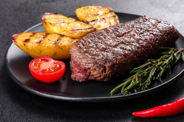 istock Ribeye steak with potatoes, onions and cherry tomatoes 1252867696