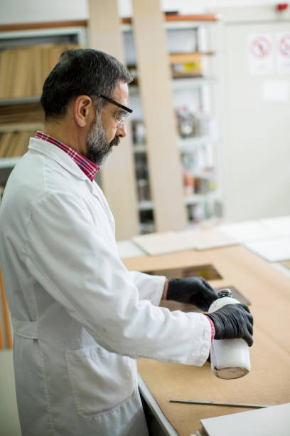 istock Handsome mature engineer in the laboratory examines ceramic tiles 1252867778