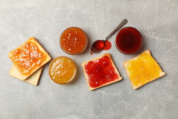 istock Bowls and toasts with jam on gray background, top view 1252869008