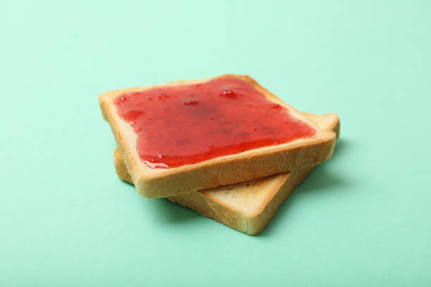 istock Toasts with strawberry jam on mint background, close up 1252870011