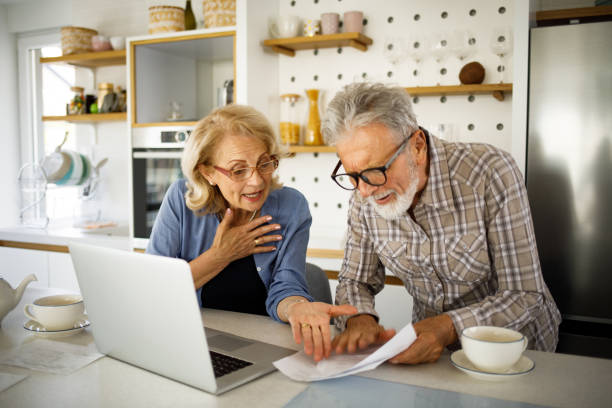istock Senior couple checking their bills using laptop in the kitchen 1252870918