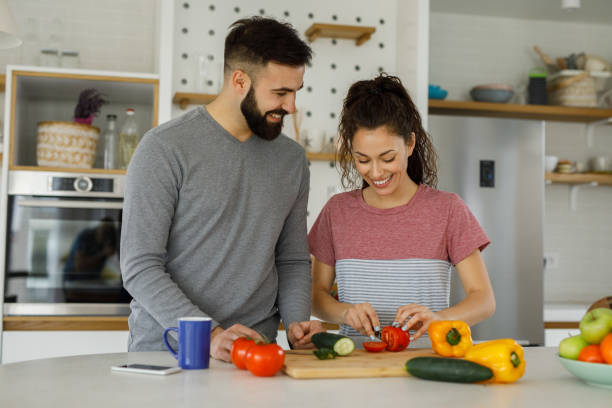 istock Affectionate couple preparing salad in a domestic kitchen 1252871110