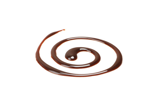 Stock photo showing close-up view of a restaurant dessert of Banoffee Pie on a white plate covered in chocolate sauce.