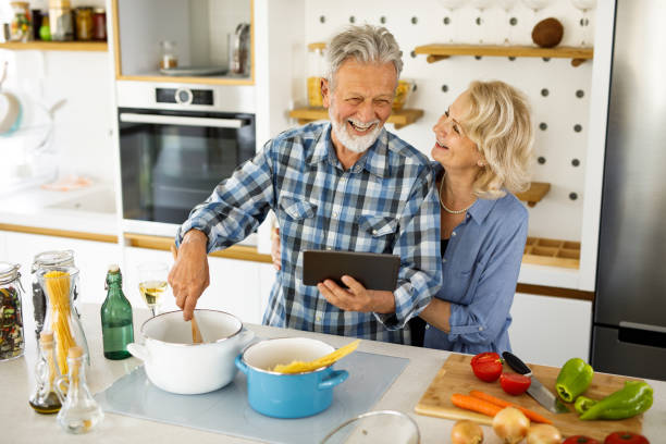istock Active senior couple cook dinner together using digital tablet 1252872153