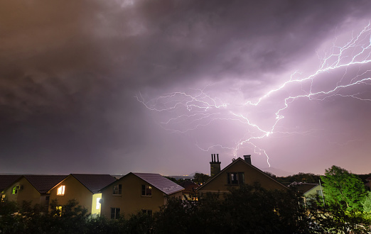 A flash of lightning against the evening sky and mountain ranges