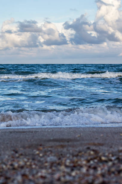 istock Sea waves, sandy beach and clouds 1252875537