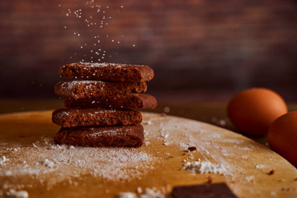 istock Chocolate cakes sprinkled with powdered sugar on a wooden table. next to it are eggs and pieces of chocolate. blurred background 1252878003