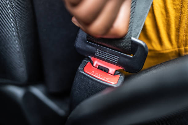 african woman buckling up seatbelt - fastening imagens e fotografias de stock