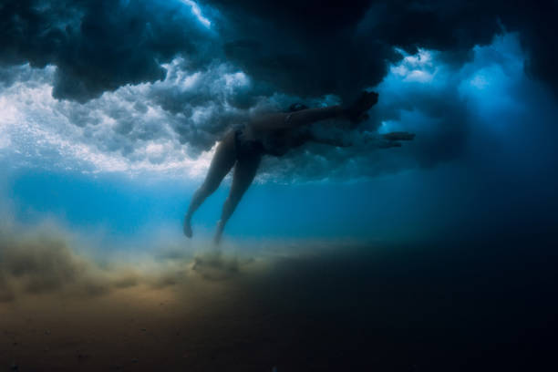 istock Woman dive without surfboard under ocean wave. Underwater duck dive under wave and sandy bottom 1252882973