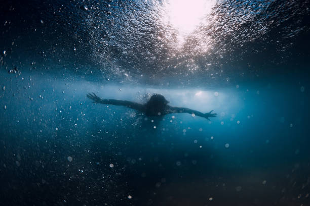 istock Woman dive without surfboard under ocean wave. Underwater duck dive under wave and sandy bottom 1252883126