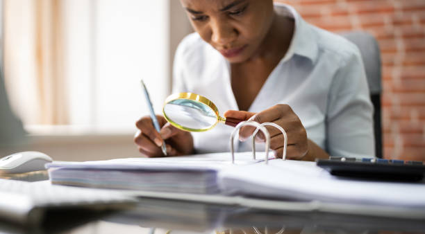 istock Auditor Investigating Fraud Using Magnifying Glass 1252883455