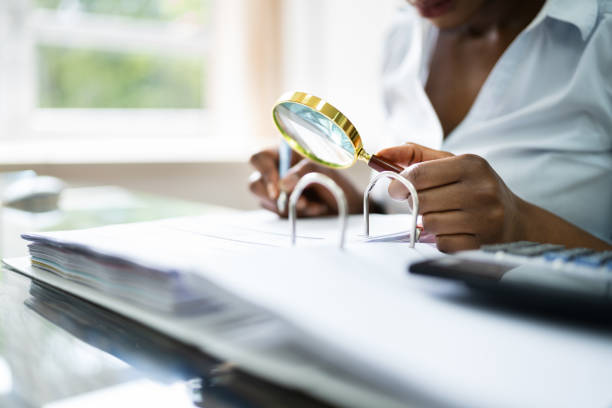 istock Auditor Investigating Fraud Using Magnifying Glass 1252883459