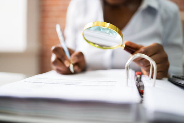 istock Auditor Investigating Fraud Using Magnifying Glass 1252883460