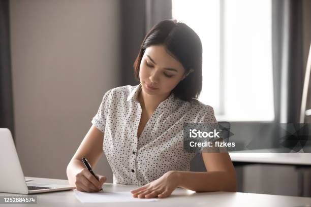 Concentrated Young Asian Business Woman Signing Important Contract Stock Photo - Download Image Now