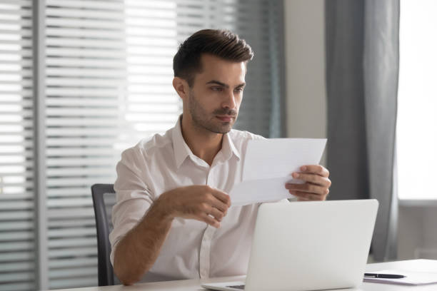 istock Concentrated young executive manager looking through financial documentation. 1252884611