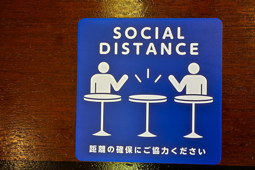 Social Distance word sticker on the table.Social Distancing Instruction against the Spread.New normal Reopen Mall, School.Social distancing in the workplace during coronavirus COVID-19.