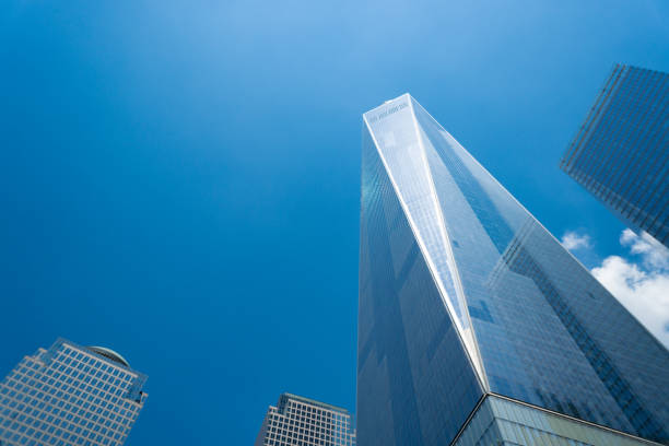 un world trade center ou freedom tower vu du bas dans un ciel d’été bleu - one world trade centre photos et images de collection