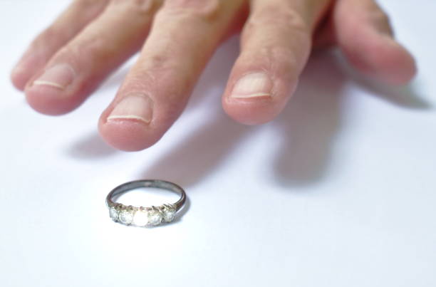 istock man hand grabbing diamond wedding ring on white background 1252894324