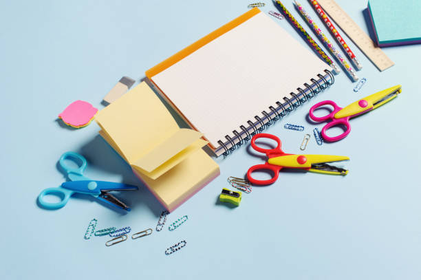 istock Top view of office tools with blank notebook on blue background 1252895225