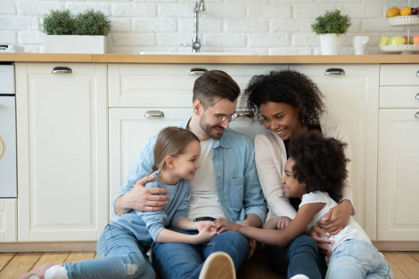 istock Multinational homeowners family with daughters resting in modern kitchen floor 1252896429