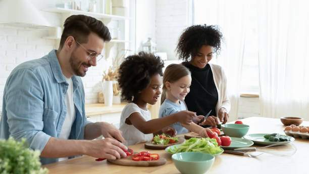 istock Full multinational family preparing dietary vegetable salad in kitchen 1252896431