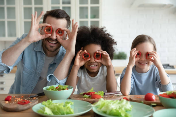istock Dad and daughters cooking having fun covering eyes with paprika 1252896448