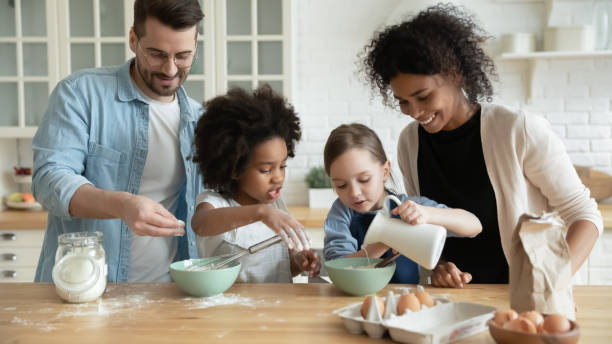 istock Full multi ethnic family cooking pancakes together in modern kitchen 1252896488