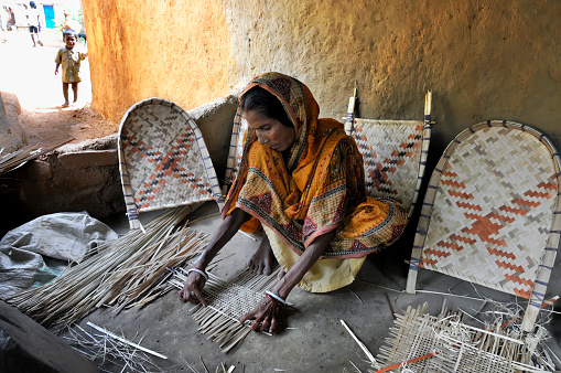 bardhaman west bengal india on 8th october 2012 : Woman basket maker with her family making bamboo cane basket, at bardhaman west bengal india, asia