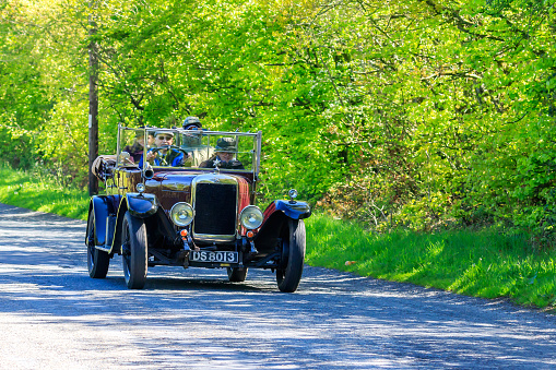 Brydekirk, Scotland - May 12, 2019: Vintage car traveling on a country lane towards the village of  Brydekirk Dumfriesshire