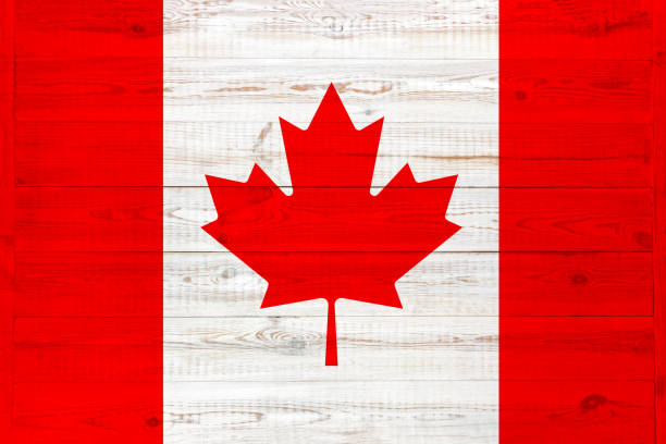 istock Canada flag painted on an old wooden background. textured scratched backdrop and concept of flag day. Red maple leaf is lined with two vertical stripes 1252901953