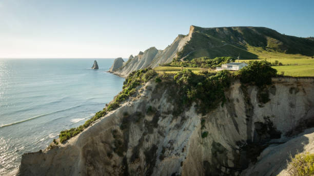 White house build on the cliff with cape and ocean in background