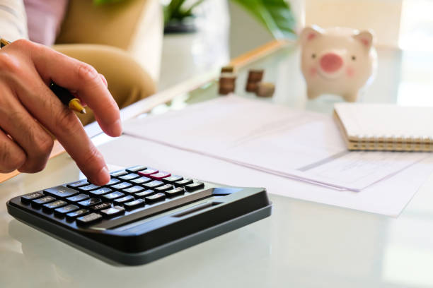 istock Selective focus of Asian men hand while calculate for personal saving with document and piggy bank at the background. 1252904720