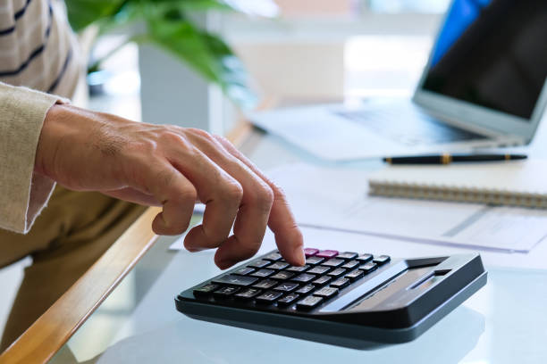 istock Selective focus of Asian men hand while calculate for personal saving with document and laptop computer at the background. 1252904729