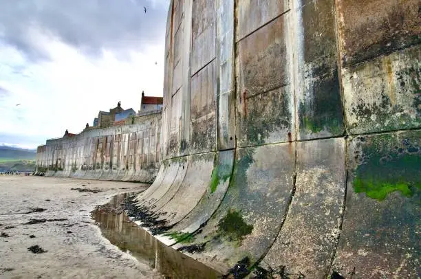 Wide angle shot of sea wall at Whitby from beach