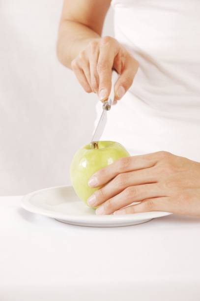 istock Woman holding green apple on plate 1252909330