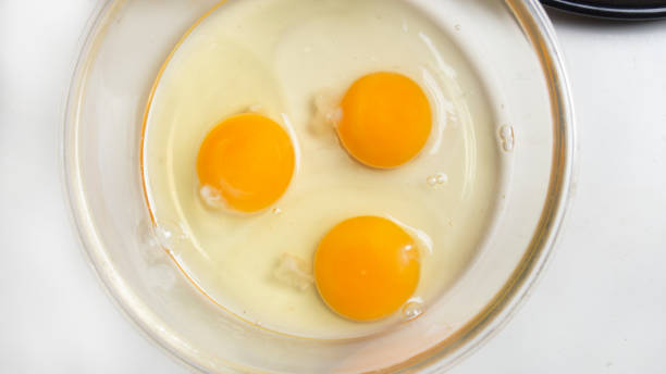 istock three broken eggs for making French omelet in a glass bowl before whipping 1252910480