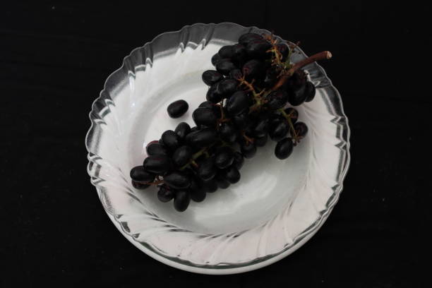 istock black grapes in white plate 1252912194