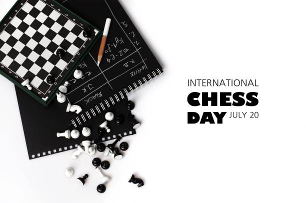 The world day of chess. International chess day. July 20. Holiday greeting poster. Small chess pieces and a chessboard are scattered on the table. White isolated background. Text. Copy space The world day of chess. International chess day. July 20. Holiday greeting poster. Small chess pieces and a chessboard are scattered on the table. White isolated background. Text. Copy space. knight chess piece photos stock pictures, royalty-free photos & images