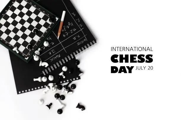 The world day of chess. International chess day. July 20. Holiday greeting poster. Small chess pieces and a chessboard are scattered on the table. White isolated background. Text. Copy space.