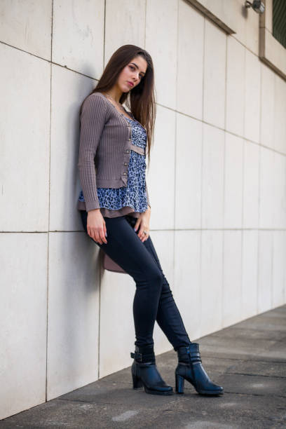 istock one young beautiful teenager girl, practising modeling poses, outdoors on a winter day. 1252913402