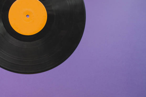 istock Black and orange vinyl record isolated on purble background 1252913553