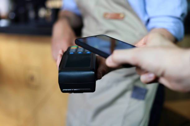 istock Customer using smartphone for payment to owner at cafe restaurant, cashless technology. 1252913834