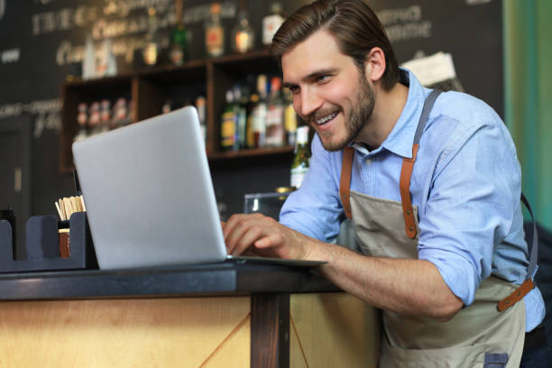 istock Restaurant manager working on laptop, counting profit. 1252913961